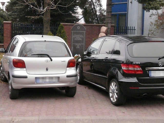 Jerzy Maszczyk chce zrobić dojście do obelisku, zasłanianego przez auta stojące na parkingu