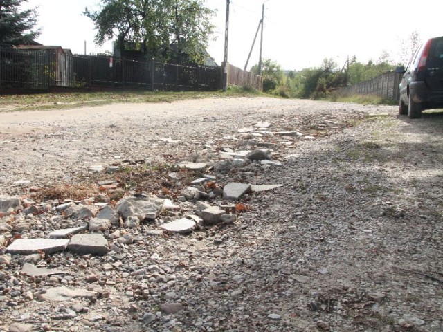 Mieszkańcy ulicy Karczunek 	własnymi sposobami łatają drogę. Dziury zasypują kamieniami, a nawet kawałkami betonowych płyt.