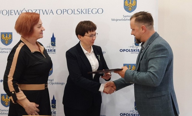 Tomasz Krawczyk dostał dotację na uruchomienie zakładu stolarskiego. Umowę wręczają (od lewej): Renata Cygan, wicedyrektor WUP w Opolu i wicemarszałek,  Zuzanna Donath-Kasiura.