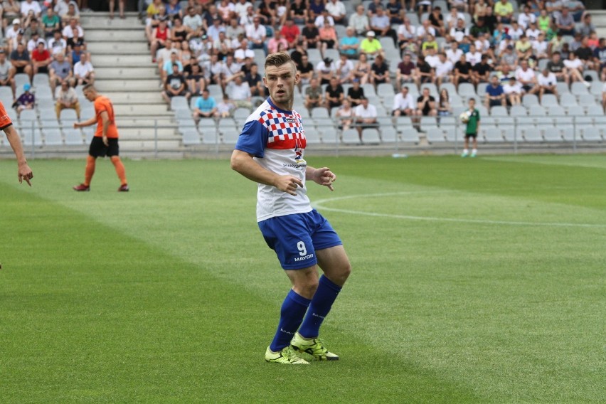 Zawodnik Granatu Skarżysko-Kamienna, Tomasz Bartosiak, biega za piłką i z pizzą 