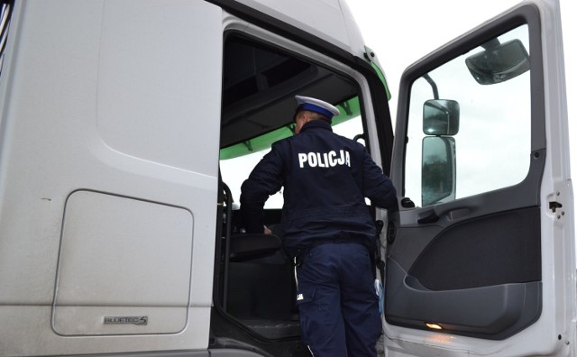 Policjanci z komendy w Oświęcimiu kontrolują stan techniczny i przygotowanie pojazdów ciężarowych do jazdy