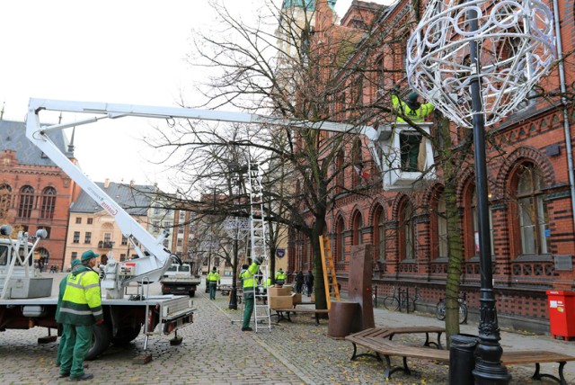 Zaczynamy wcześnie, bo jest tego naprawdę dużo. Nad koncepcją iluminacji pracowaliśmy praktycznie od wiosny. Będzie to ogromne przedsięwzięcie, dlatego realizacja zostanie rozłożona na cztery lata.  W tym roku wykorzystamy oczywiście ozdoby z ubiegłych lat, ale pojawią się także nowe - wyjaśnia Krzysztof Nowacki z Wydziału Gospodarki Komunalnej UMT.

Więcej informacji o toruńskiej iluminacji świątecznej znajdziesz: TUTAJ

Montaż dekoracji świątecznej w roku bieżącym będą realizowały dwie firmy: Elkard Sp z o.o. Sp.K, i Energa Oświetlenie Sp. z o.o. Pierwsza rozpocznie montaż dekoracji od 17.11.2017 r. Będą to ozdoby nowe i z poprzedniego sezonu.

Trwa montaż iluminacji świątecznej na toruńskiej starówce [ZDJĘCIA]