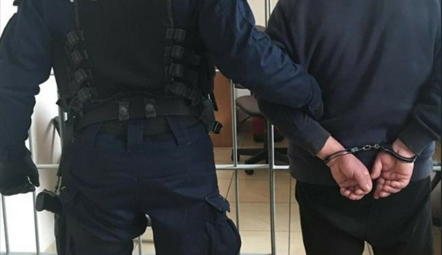 Policjant z zatrzymanym mężczyzną. Zdjęcie ilustracyjne