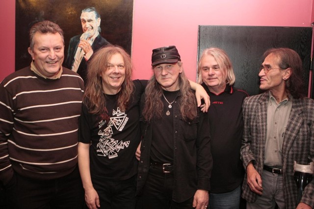 W środku część historycznego  składu grupy Turbo: gitarzysta Wojciech Hoffmann, basista Henryk Tomczak i perkusista Wojciech Anioła. Z lewej i prawej długoletni menedżerowie  Marek Wajchti Janusz Maślak