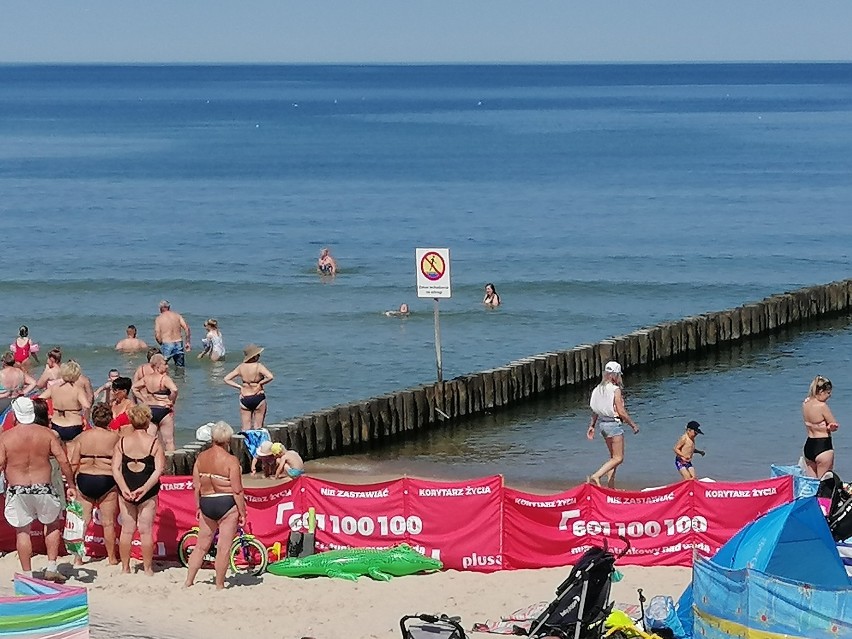 Plażowanie w Ustroniu Morskim. Z widokiem na malownicze molo, pod okiem ratowników