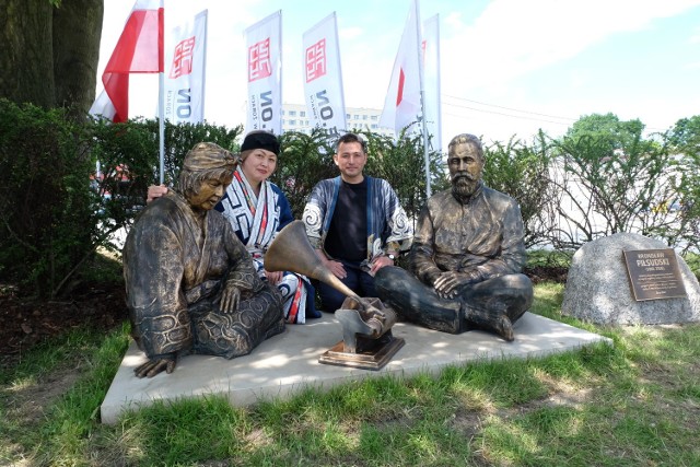 Na zdjęciach Maki i Kenji Sekine – małżeństwo w siedmioosobowej delegacji z Biratori – gminy, która stanowi jedną z największych społeczności ajnuskich na Hokkaido. Maki jest artystką, znawczynią tradycyjnych motywów zdobniczych. Kenji pracuje w Muzeum Kultury Ajnuskiej i biegle mówi po ajnusku. Maki zaprojektowała posąg, który stanął przez żorskim muzeum. Oboje w trakcie pobytu w Żorach prowadzą zajęcia plastyczne dla dzieci, oprowadzają je w przestrzeni wystawy, opowiadając o Ajnach i ich kulturze.