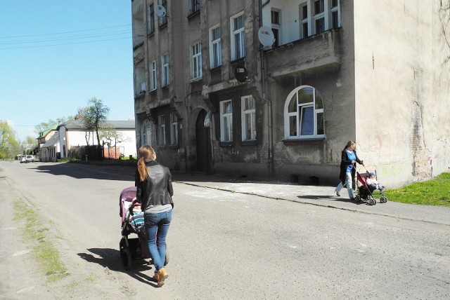 Przechodnie przyglądają się pozostałościom po fragmentach elewacji, które w ubiegłym tygodniu spadły na chodnik.