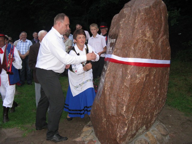 Tomasz Brzoskowski, wójt Stężycy i Mirosława Miodowska-Jaroś odsłaniają obelisk przypominający stary gród nad jeziorem Zamkowisko